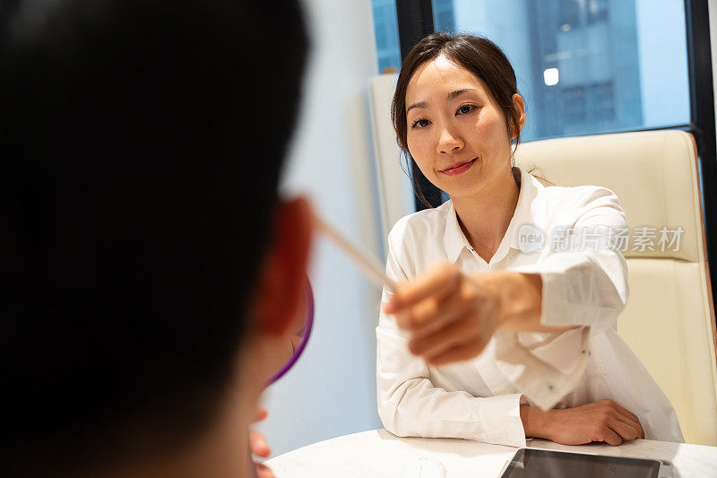 一位亚洲女性美容顾问/美容医生正在与一位亚洲男性客户进行咨询。